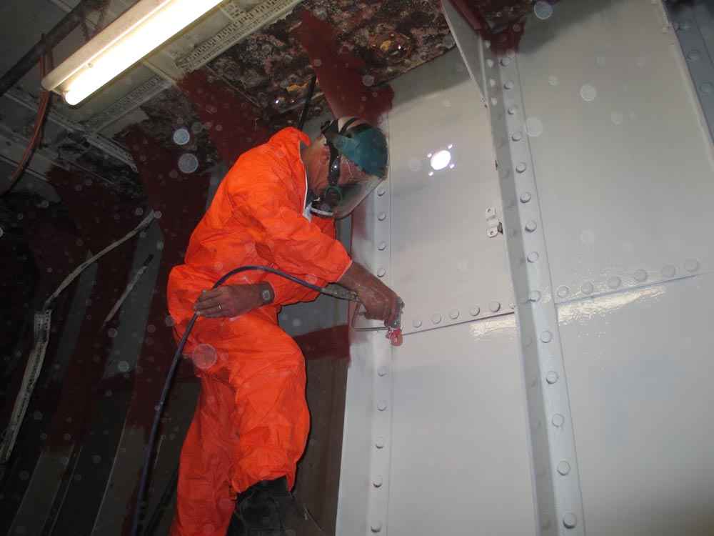 Ian spray painting hull inside engine room