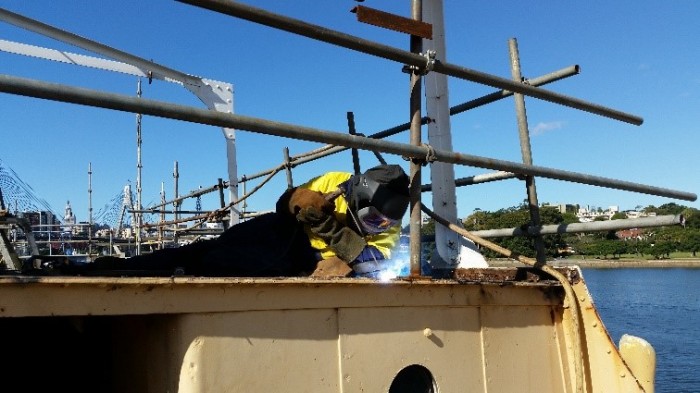 Apprentice welding to produce watertight seal on boat deck plates